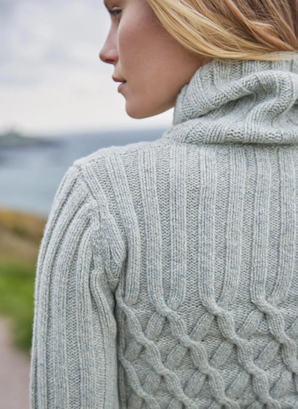detail shot of woman wearing a neutral colored turtle neck aran sweater