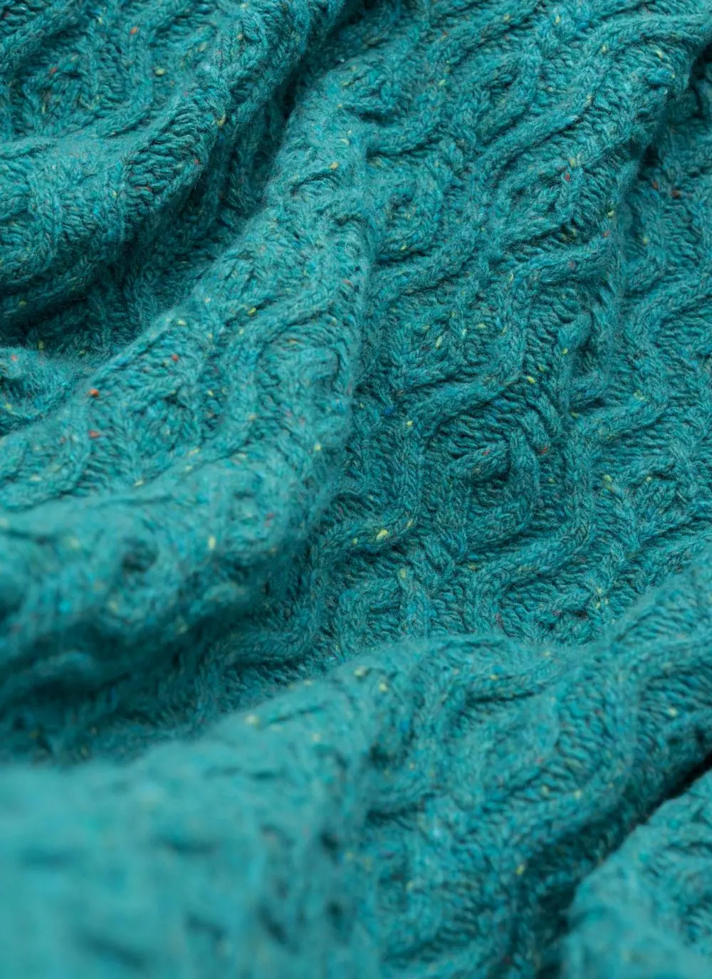 Jade colored wool cashmere aran throw with flecks of color throughout