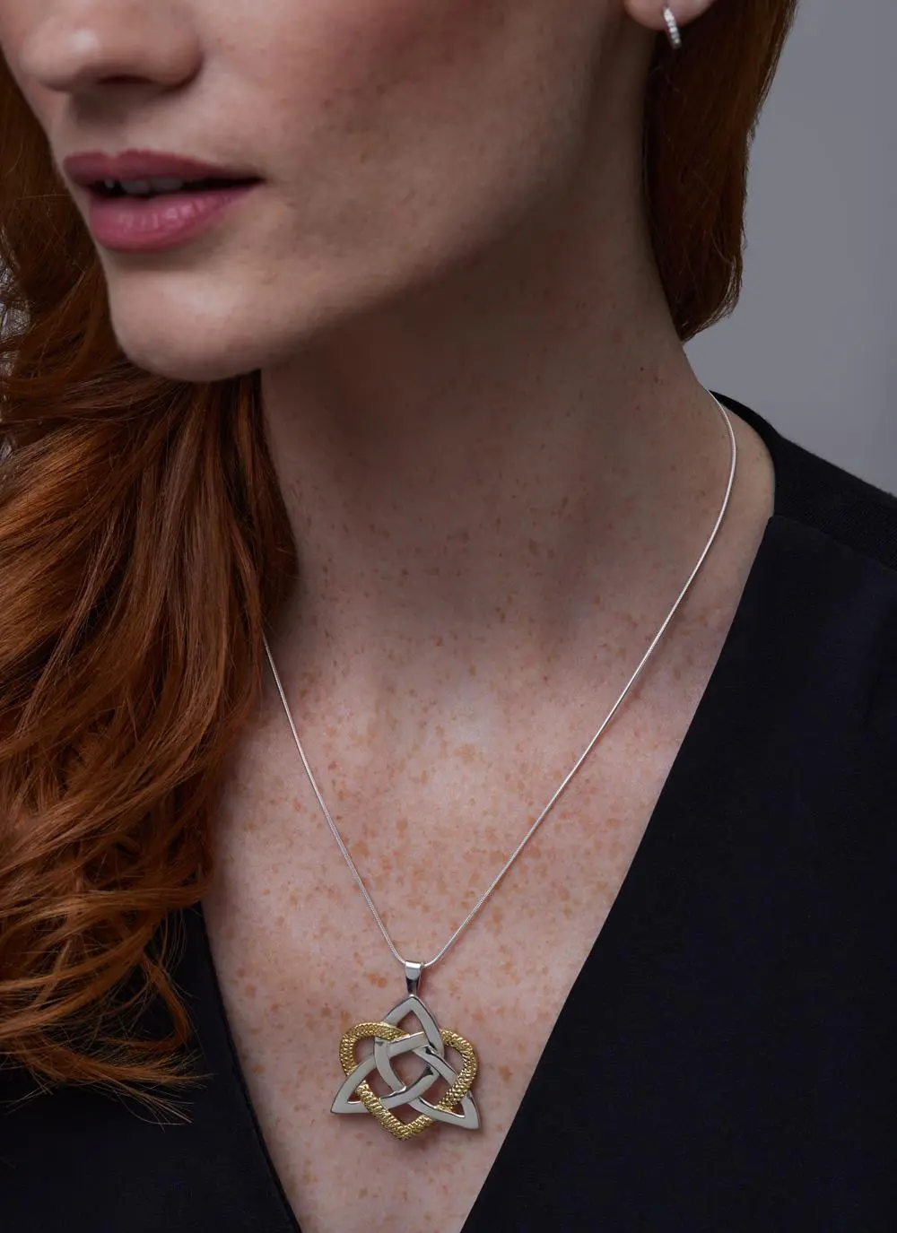 Close up shot of red haired model wearing Two Tone Heart Of A Celt Pendant