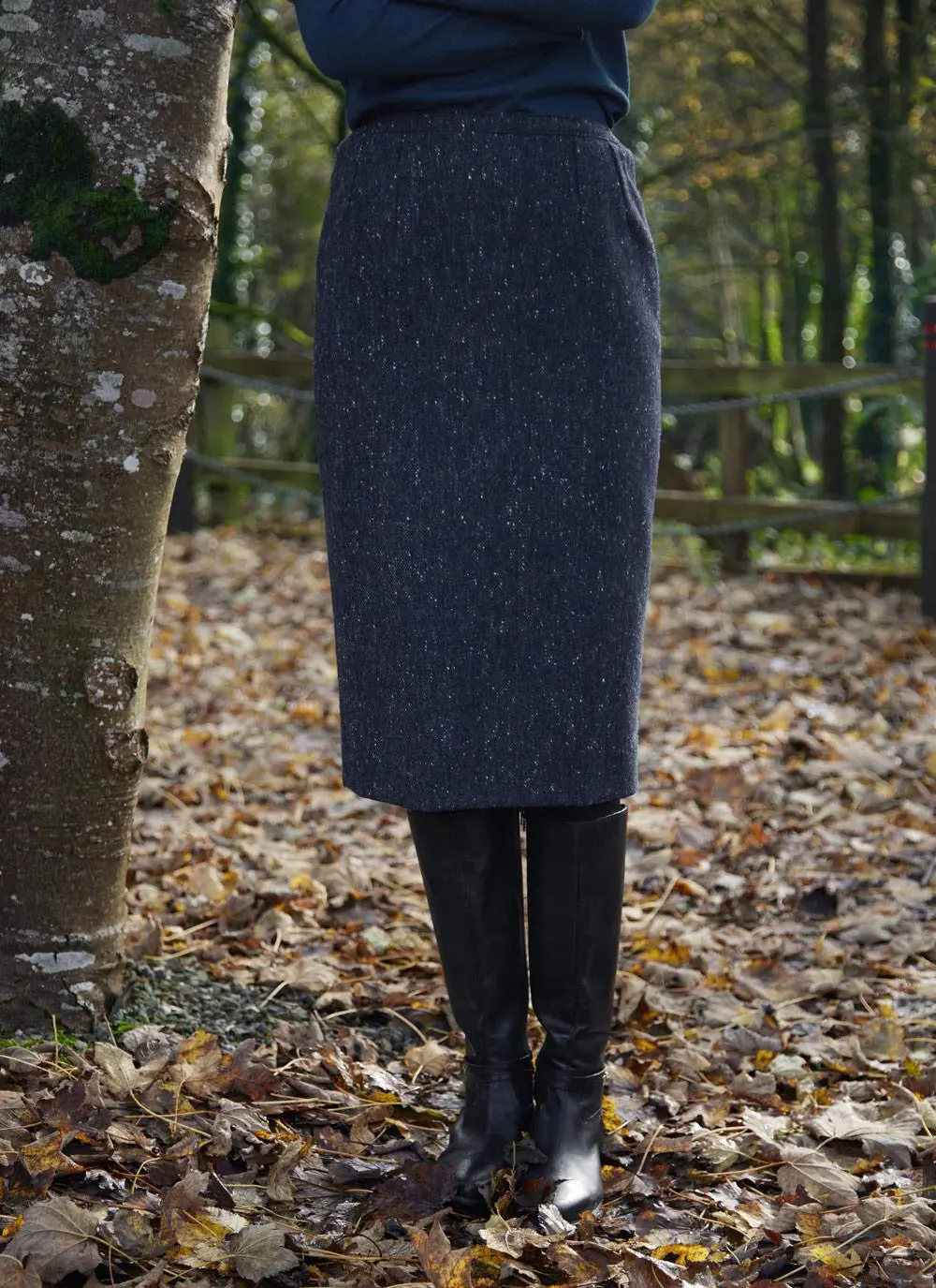 Woman standing in forest wearing denim tweed straight skirt, front 